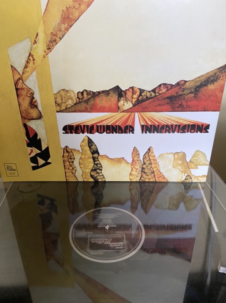 The album cover “Innervisions” by Stevie Wonder sits above the vinyl record spinning below it.